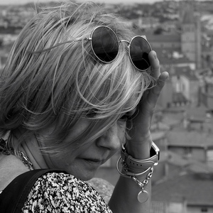 Femme blonde et lunettes de soleil sur la tête devant un ensemble de maisons - France  - collection de photos clin d'oeil, catégorie portraits